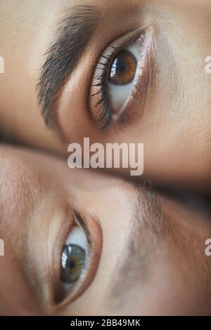 Extreme close up of male and female eyes looking at camera, love and couple concept