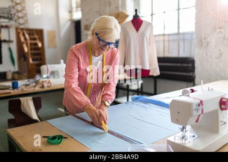 Confident senior fashion designer in her workshop Stock Photo
