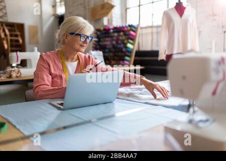 Confident senior fashion designer in her workshop Stock Photo