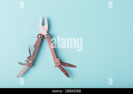 The multitool multi-function tool hovers on a blue background. The concept of an expanded multi-tool with free space. Stock Photo