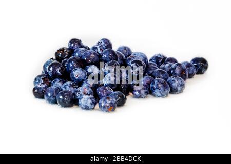 Delicious seasonal fruits, Several loose blueberries, mixed together on a white top against a white background. A perfect healthy breakfast or snack.