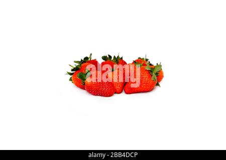 Delicious seasonal fruits, Several loose strawberries, mixed together on a white top against a white background. A perfect healthy breakfast or snack.