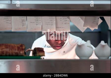 A kitchen assistant/cook at work in the kitchen at The Station Cafe Bar in Richmond, North Yorkshire, UK. 21/9/2018. Photograph: Stuart Boulton. Stock Photo