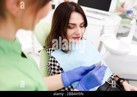 Dentist shows patient a model of teeth Stock Photo