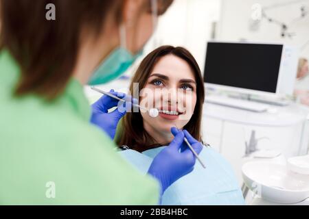 Girl with a beautiful smile at the dentist's appointment. Dentist examines a patient’s teeth Stock Photo