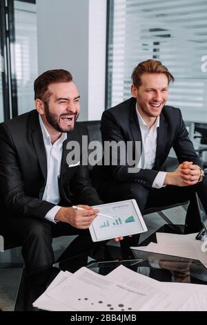 Meeting the business team, working with a new startup project, discussing and analyzing data from charts and graphs. Digital tablet, calculator, lapto Stock Photo