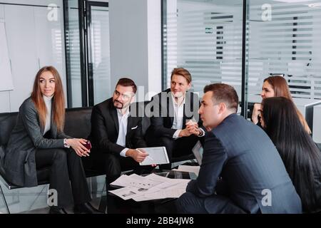 manager discussing work with his colleagues,meeting business partners in a modern office,A group of successful businessmen. Discussion of an important Stock Photo