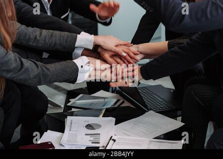 diverse workers or employees put hands in stack showing support and unity, reach shared goal together, people engaged in teambuilding activity or trai Stock Photo