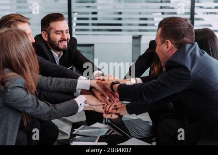 diverse workers or employees put hands in stack showing support and unity, reach shared goal together, people engaged in teambuilding activity or trai Stock Photo