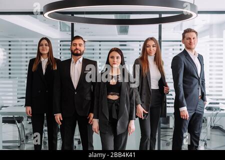 Diverse professional business leaders posing with workers in office, corporate coaches mentors stand together with employees group, happy staff people Stock Photo