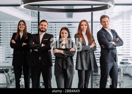 Diverse professional business leaders posing with workers in office, corporate coaches mentors stand together with employees group, happy staff people Stock Photo