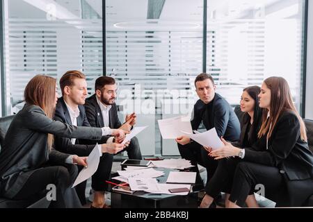 Male and female professionals having discussion at table in new office Stock Photo