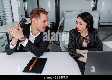 two call center employees are talking to each other Stock Photo