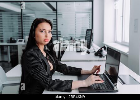 A young employee working with a headset and accompanying team Stock Photo