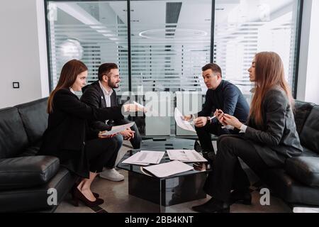 Male and female professionals having discussion at table in new office Stock Photo
