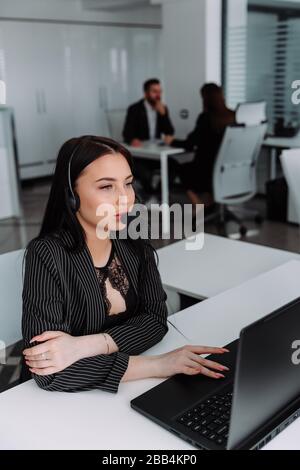 A young employee working with a headset and accompanying team Stock Photo