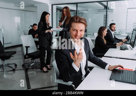 smiling friendly professional technical support manager call center operator assistant wearing headset with mic answering consulting clients. Stock Photo