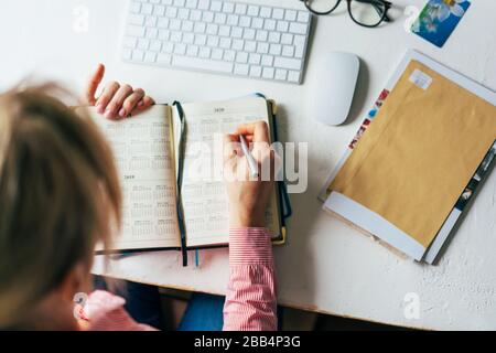 .top view woman writes on calendar Stock Photo