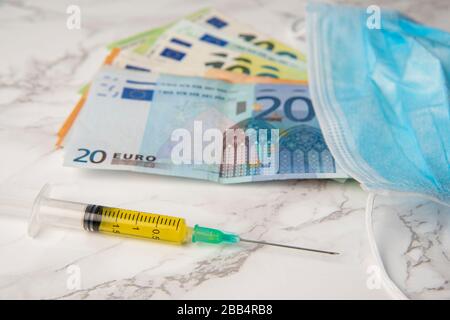 cost of coronavirus breakdown in europe Euro banknotes and vaccine Stock Photo