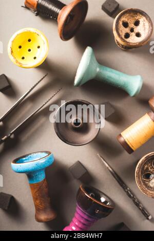 Different types of clay cups for hookah tobacco on a gray background. Top view layout. Stock Photo