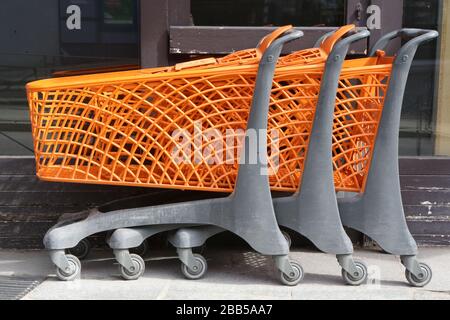 Caddies oranges alignés le long d'un supermarché. Saint-Gervais-les-Bains. Haute-Savoie. Stock Photo