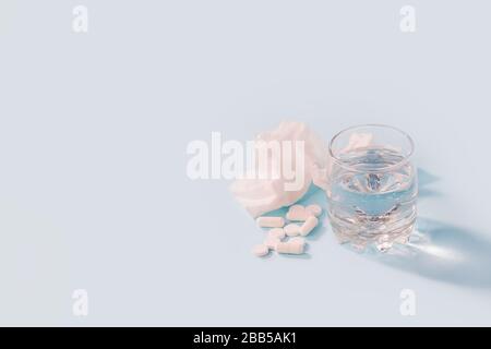Vaccines Covid-19 Antivirus Corona virus. Glass of water and set of pill on blue background, minimal concept of antivirus pharmacy, Prevention of the Stock Photo