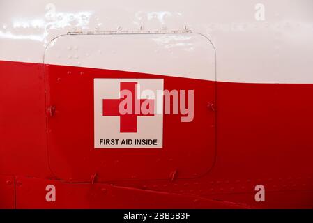 First aid cross and first aid inside title on a metal cabinet door on a aircraft body Stock Photo