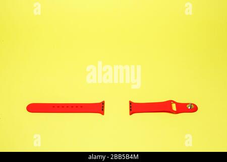 silikone strap for smart watch red color on yelow background Stock Photo