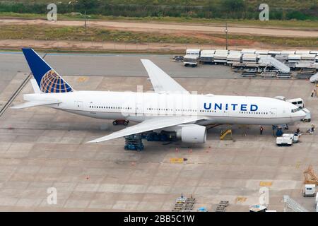 United Airlines Boeing 777 parked in a remote stand at Guarulhos Airport (GRU) Mechanical work and washing happening between long flights. Aerial view. Stock Photo