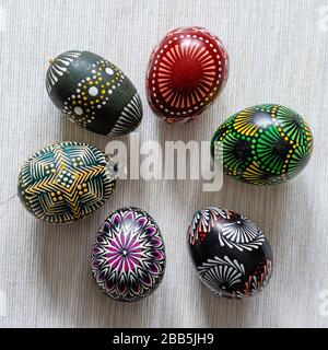 Six multicolored Easter eggs lithuanian traditional painted with beeswax on a brownish striped background. Natural,  for decoration, ceramic Stock Photo