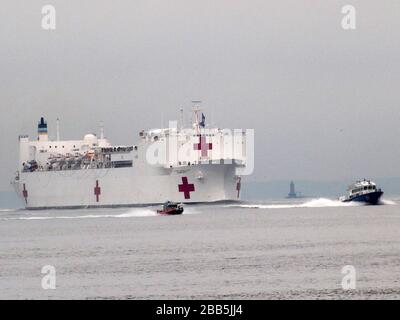March 30, 2020, New York, New York, USA: The Hospital Ship USNS Comfort arrives in New York.  USNS Comfort sail under the Verrazano Narrows bridge then proceeds to go past the Statue of Liberty to it's berth at pier 90 on the Westside of Manhattan (Credit Image: © Bruce Cotler/Globe Photos via ZUMA Wire) Stock Photo