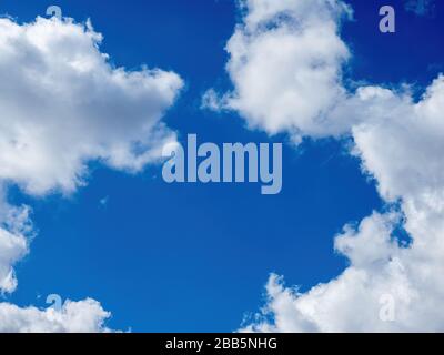 puffy white clouds on a bright blue sky Stock Photo
