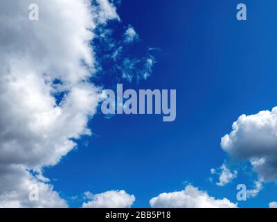 puffy white clouds on a bright blue sky Stock Photo
