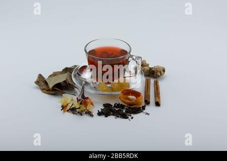 Close-up of a cup of herbal tea and various herbs on white background Stock Photo