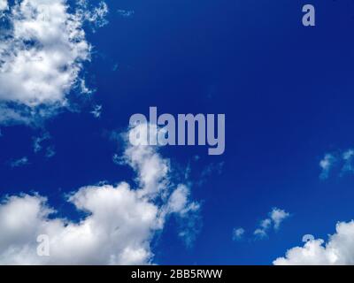 puffy white clouds on a bright blue sky Stock Photo
