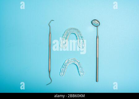 Transparent dental aligner next to dentist mirror, copy space. Stock Photo