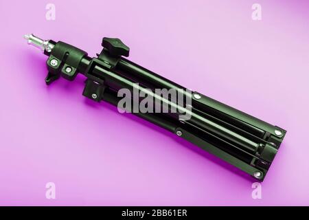 Tripod on pink background for photo-video camera and flash. Free space Stock Photo