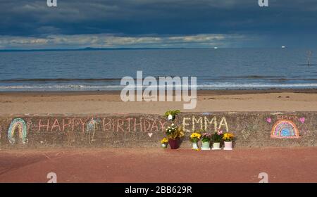 Portobello, Edinburgh, Scotland, UK. 30th Mar 2020. Chalk drawing by unknown artist on promenade wall wishing Emma a Happy Birthday. Viewer could speculate this is because Emma cannot have a proper Birthday Party with friends and family due to the Coronavirus. Stock Photo