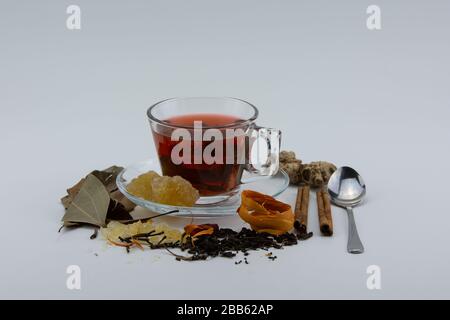 Close-up of a cup of herbal tea and various herbs on white background. Stock Photo