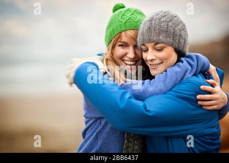 Two female friends hugging at the beach. Stock Photo