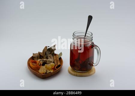 Close-up of a glass of ginger tea and various herbs. Stock Photo