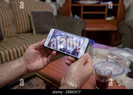 (200330) -- BETHLEHEM, March 30, 2020 (Xinhua) -- A Palestinian watches an internet broadcast of Sunday Mass from an Orthodox church in Beit Sahour near the West Bank city of Bethlehem on March 29, 2020. For the first time ever, Raed al-Atrash, a 54-year-old Palestinian man from the West Bank city of Bethlehem, attended the Sunday Mass with his family through a live TV broadcast, as the churches are closed as part of the precautions against the spread of the novel coronavirus.TO GO WITH 'Feature: Christians in Palestine attend live prayers as churches close over coronavirus fears' (Photo by Lu Stock Photo