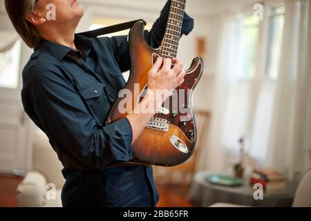 Mature man playing an electric guitar. Stock Photo