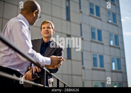 Business colleagues talking on an office balcony. Stock Photo