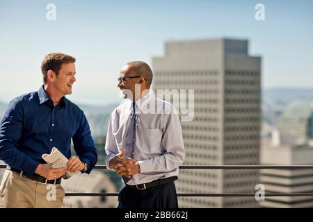 Business colleagues talking on an office balcony. Stock Photo