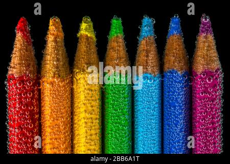 Multi coloured pencils submerged in water Stock Photo