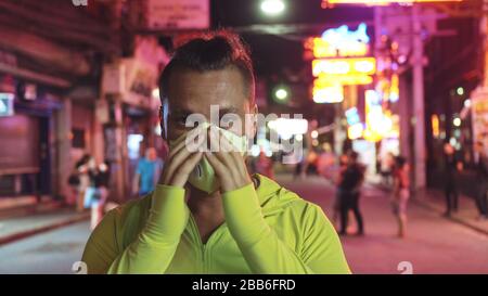 Man close up look caucasian at Pattaya Walking Street with wearing protective medical mask. Lockdown quarantine isolation. Coronavirus covid-19. Stock Photo
