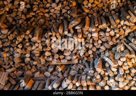 Firewood stacked on each other in a barn. Chopped fire wood background Stock Photo