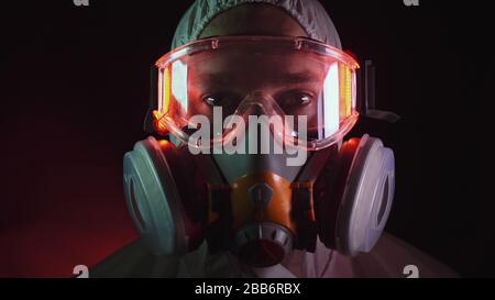 Man in protective costume suit, gas protect medical spray paint mask. Doctor in respirator. Concept health virus coronavirus epidemic. Stock Photo