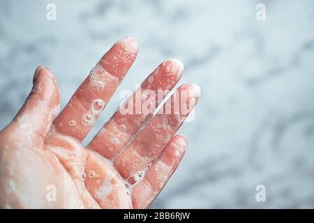 Washing hands woman on marble background, Coronavirus prevention hand hygiene. Corona Virus pandemic protection by cleaning hands. Outbreak of coronavirus concept. Novel virus - COVID-19, 2019-nCoV. Stock Photo